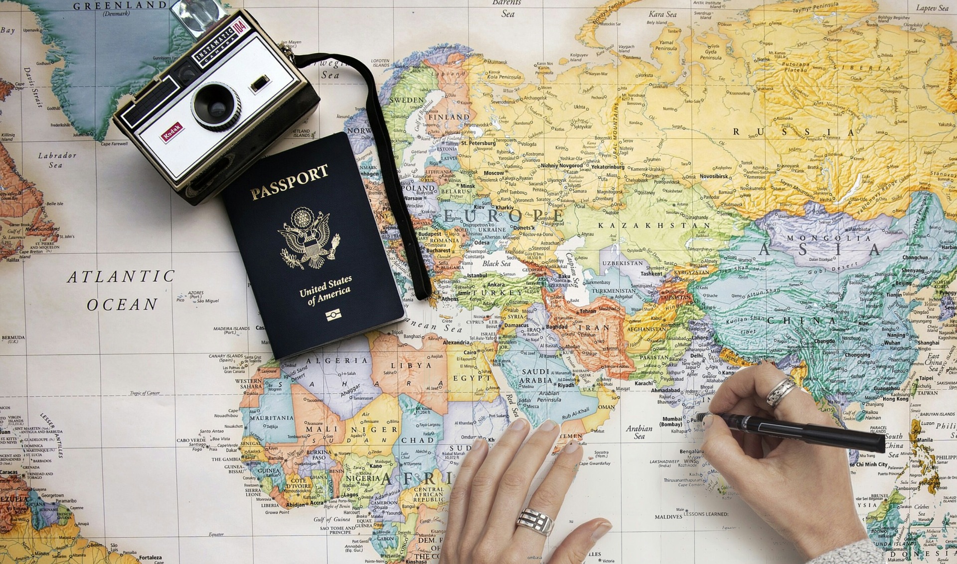 Pessoa com um mapa e seu passaporte programando viagens em grupo da melhor forma