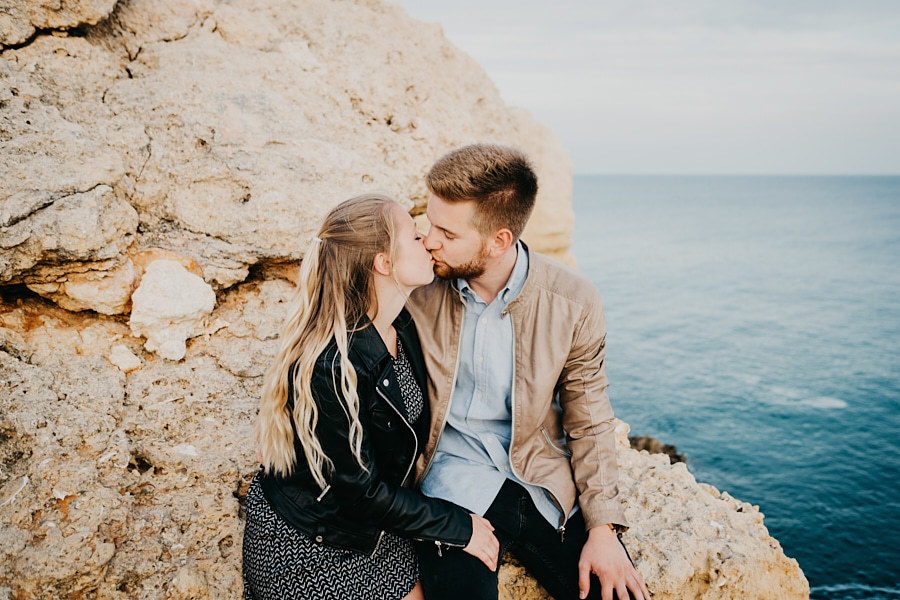 Casal se beijando em uma praia de Algarve, destino surpreendente para a lua de mel na Europa