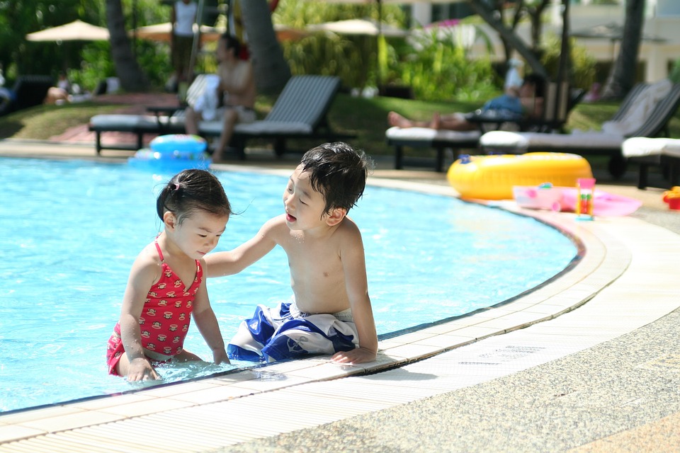 duas crianças brincando na piscina