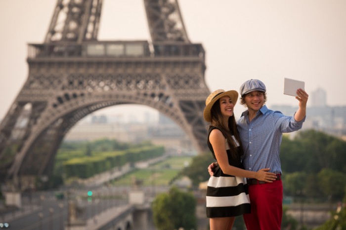 Casal em Paris, em frente à Torre Eiffel, um dos monumentos mais românticos para a lua de mel na Europa